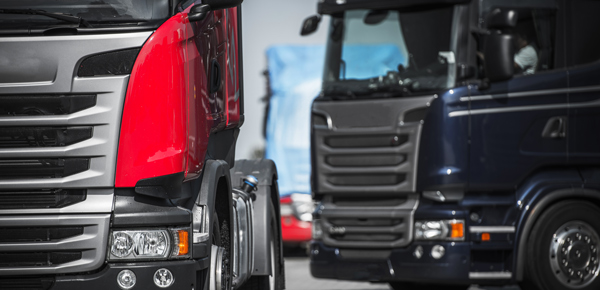 red and black trucks in focus with contrasting colors parked at a location showcasing modern design and efficiency in transportation