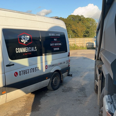 SJP Commercials van parked in a service area with a tree line in the background showcasing reliable services and vehicle maintenance options