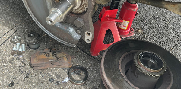 car brake components and tools on the ground during repair process three essential parts visible