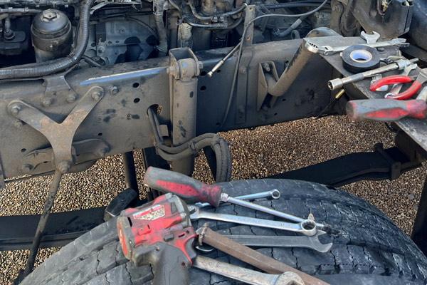 tools and equipment on tire near truck frame for vehicle maintenance